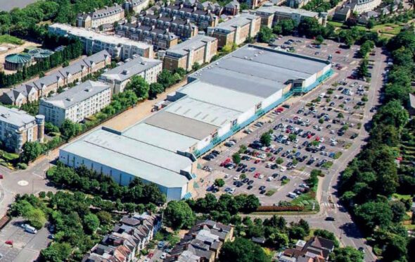 Aerial image of the Kew Retail Park showing the stores and car park surrounded by trees and houses