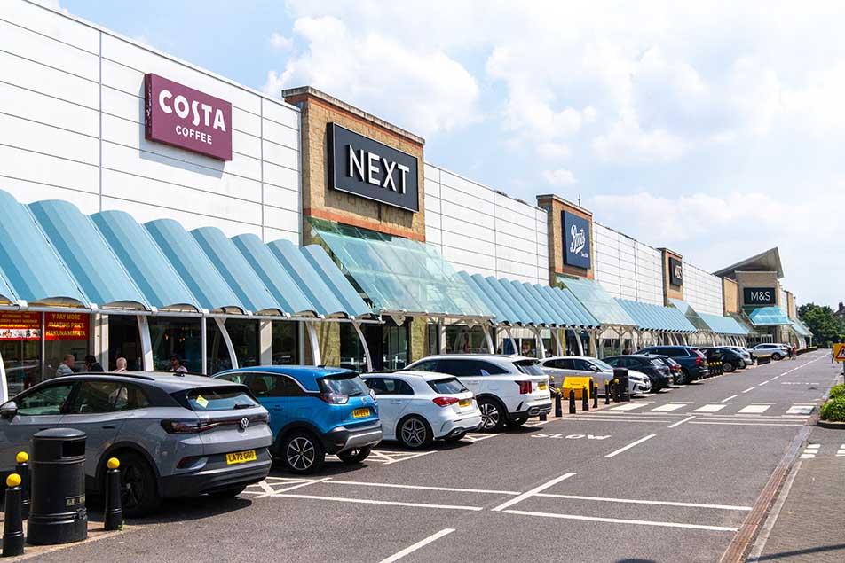 image of Costa and Next stores and others in the Kew Retail Park with cars parked in bays outside