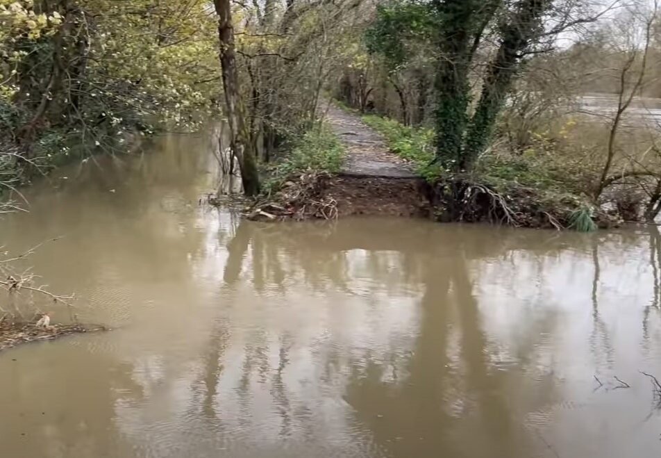 Image from council video showing a large 10 metre wide breach in the bank of the Thames, flooded with water